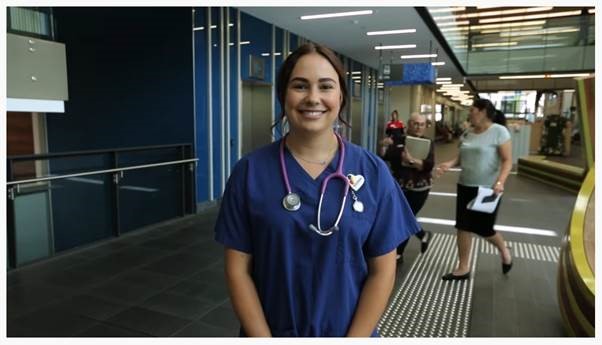 Registered nurse smiling in hospital with stethoscope around her neck.