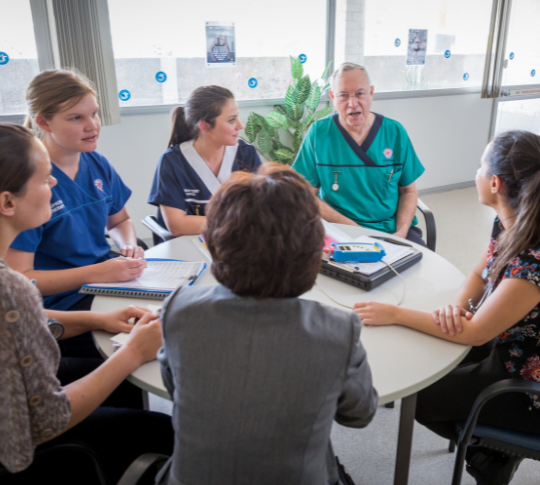 Group of nurses sitting around a table discussing