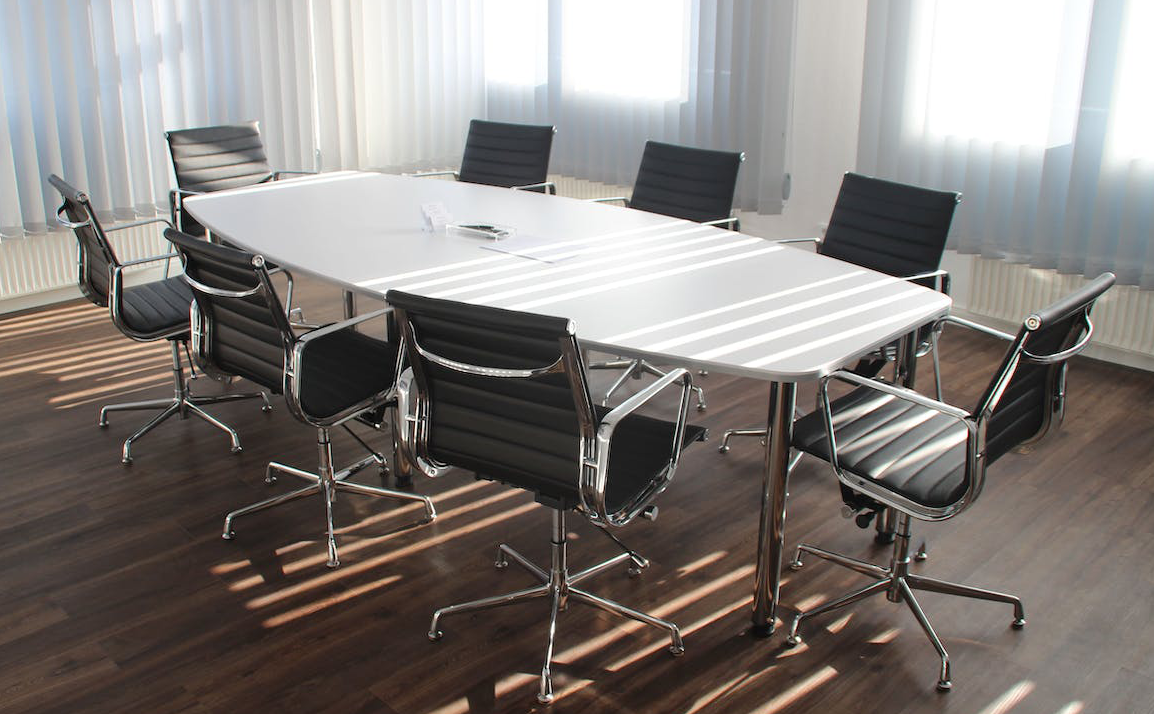 empty boardroom: white table and and 7 black chairs