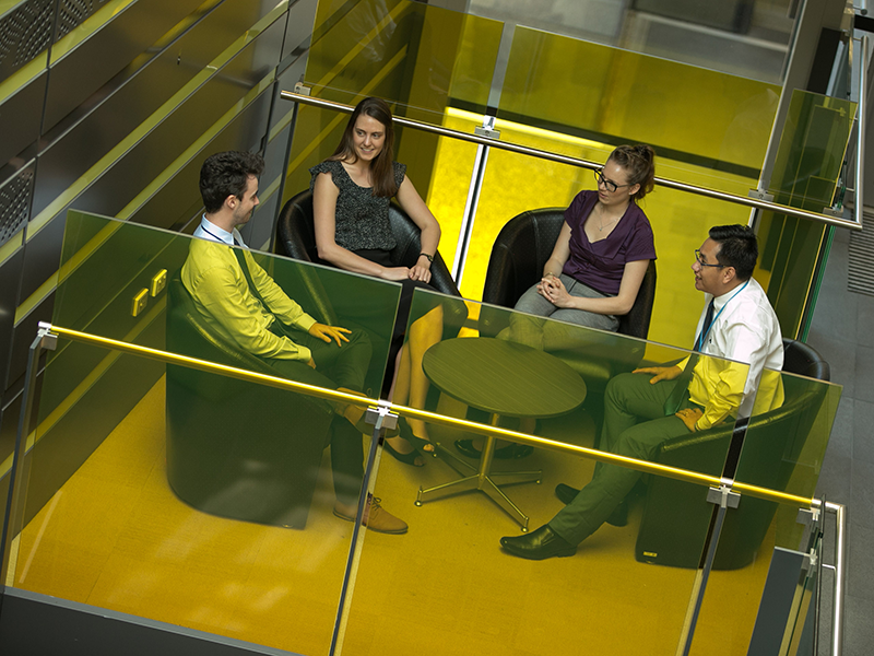 four people sitting around a coffee table talking