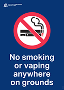 Sign displaying a no smoking symbol with a line through a burning cigarette and text “No smoking anywhere on grounds"