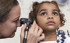 Doctor checking girls ear