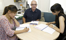 Three researchers at table, examining the data