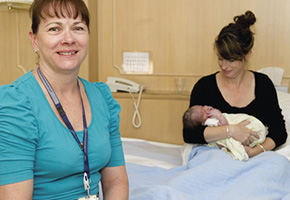 Nurse with new mother in hospital with her new born baby
