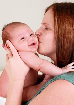 Mother kissing baby on cheek